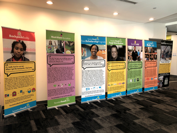 Brightly colored posters lined up in a row with photos and descriptions of various programs offered by the Houston Food Bank.