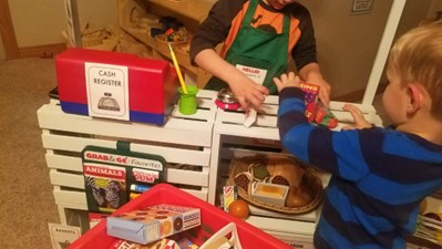 Children playing with their grocery store toys at home