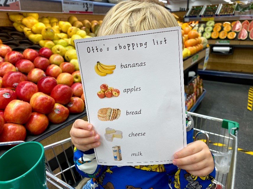 A child holing a grocery shopping list