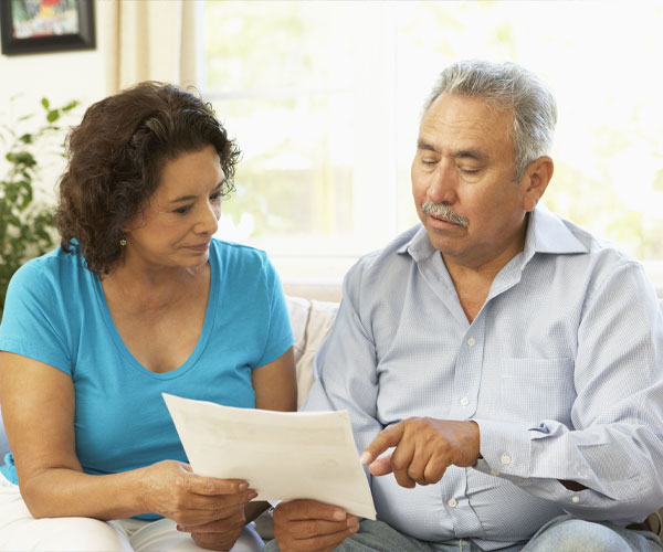 Housing-600×500 An older couple review paperwork together.