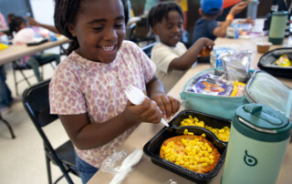 A young girl prepares to eat her lunch.