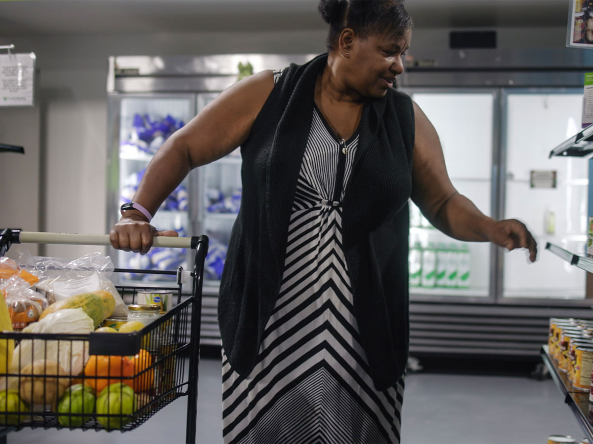A neighbor filling her basket at the Houston community resource center